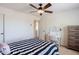 Bright bedroom with a ceiling fan, vanity table, and a striped comforter at 9998 W Prospector Dr, Queen Creek, AZ 85144