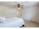 Cozy bedroom featuring a ceiling fan and neutral carpet complemented by white walls and trim, and soft, plush bedding at 9998 W Prospector Dr, Queen Creek, AZ 85144