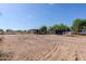Wide shot of the equestrian arena showcasing horse stables and trailer parking area in a sandy lot at 9998 W Prospector Dr, Queen Creek, AZ 85144