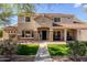 Charming front exterior showcasing a two-story home with a manicured lawn and stone accents at 9998 W Prospector Dr, Queen Creek, AZ 85144