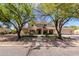 Two-story home with a landscaped front yard and mature trees in a desert landscape at 9998 W Prospector Dr, Queen Creek, AZ 85144