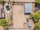 Aerial view of a horse property, featuring stables, fencing, a riding area, and mature landscaping at 9998 W Prospector Dr, Queen Creek, AZ 85144