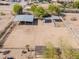Aerial view of a horse property, showcasing stables, fencing, and a large riding area at 9998 W Prospector Dr, Queen Creek, AZ 85144