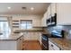 Bright kitchen with granite countertops, white cabinets, stainless steel appliances, and tile flooring at 9998 W Prospector Dr, Queen Creek, AZ 85144