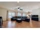 Spacious living room featuring a ceiling fan, leather sectional, tile flooring, and lots of natural light at 9998 W Prospector Dr, Queen Creek, AZ 85144