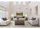 Bright living room with high ceilings, neutral tones, and modern furnishings exudes comfort at 9998 W Prospector Dr, Queen Creek, AZ 85144