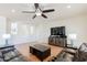 Bright living room with a ceiling fan, tile floors, dark wood accents, and comfortable leather seating at 9998 W Prospector Dr, Queen Creek, AZ 85144