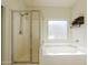 Relaxing bathroom featuring a separate glass shower and a soaking tub under a bright window at 9998 W Prospector Dr, Queen Creek, AZ 85144