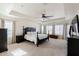 Spacious main bedroom with a tray ceiling, plush carpet, and a large window for natural light at 9998 W Prospector Dr, Queen Creek, AZ 85144