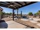 Backyard featuring a rock waterfall pool with a pergola and string lights for ambiance on a sunny day at 9998 W Prospector Dr, Queen Creek, AZ 85144