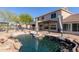 Relaxing backyard pool with rock features and covered patio, perfect for outdoor entertaining and enjoying sunny days at 9998 W Prospector Dr, Queen Creek, AZ 85144