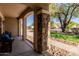 Charming porch with stone pillar accents, offering a welcoming entry and a relaxing outdoor seating area at 9998 W Prospector Dr, Queen Creek, AZ 85144