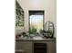 Stylish bar area with custom cabinets, wine cooler, and charming desert view from the window at 10040 E Happy Valley Rd # 1011, Scottsdale, AZ 85255