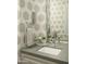 Elegant bathroom featuring a gray vanity with modern fixtures, vanity mirror, and patterned wallpaper at 10040 E Happy Valley Rd # 1011, Scottsdale, AZ 85255