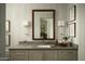 Stylish bathroom featuring a gray vanity with framed mirror, sconces, and artistic botanical prints at 10040 E Happy Valley Rd # 1011, Scottsdale, AZ 85255