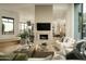 Open-concept living room with a fireplace, large windows, and views into the kitchen at 10040 E Happy Valley Rd # 1011, Scottsdale, AZ 85255