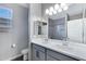 Bathroom with double sinks, large mirror, gray tile backsplash and a window at 1090 E Horro Rd, Queen Creek, AZ 85143