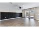 Living room featuring dark wainscoting, accent wall, ceiling fan, tiled flooring, and sliding glass doors at 1090 E Horro Rd, Queen Creek, AZ 85143