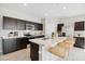 Modern kitchen with dark cabinets, stainless steel appliances, marble countertops, and a center island with bar seating at 1331 S Vista Ave, Florence, AZ 85132