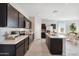 Contemporary kitchen featuring dark cabinetry, stainless steel appliances, a marble island, and an adjacent dining area at 1331 S Vista Ave, Florence, AZ 85132