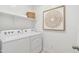 Clean and functional laundry room with white washer and dryer, and built-in shelving at 1331 S Vista Ave, Florence, AZ 85132