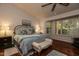 Comfortable bedroom featuring a bay window, ceiling fan and bench seating at the foot of the bed at 13731 W Greenview Dr, Sun City West, AZ 85375