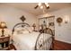 Bright bedroom featuring decorative metal bed frame, mirrored closet doors and dark wood floors at 13731 W Greenview Dr, Sun City West, AZ 85375
