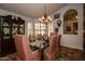 A dining room featuring a glass-top table, upholstered chairs, and a decorative chandelier provides an elegant space at 13731 W Greenview Dr, Sun City West, AZ 85375
