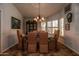 A dining room featuring a glass-top table, upholstered chairs, and a decorative chandelier provides an elegant space at 13731 W Greenview Dr, Sun City West, AZ 85375