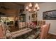 A dining room featuring a glass-top table, upholstered chairs, and a decorative chandelier provides an elegant space at 13731 W Greenview Dr, Sun City West, AZ 85375