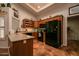 A kitchen featuring wood cabinets, black appliances, and terracotta tile flooring provides a functional and appealing space at 13731 W Greenview Dr, Sun City West, AZ 85375