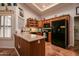 A kitchen featuring wood cabinets, black appliances, and terracotta tile flooring provides a functional and appealing space at 13731 W Greenview Dr, Sun City West, AZ 85375