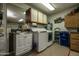 Clean laundry room featuring a washer, cabinets, utility sink, and recycling bin at 13731 W Greenview Dr, Sun City West, AZ 85375