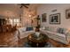 Inviting living room flows into dining area, featuring tile flooring, high ceilings, and chandelier at 13731 W Greenview Dr, Sun City West, AZ 85375