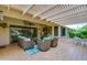 Covered patio with comfortable seating arrangement and view of the backyard at 13731 W Greenview Dr, Sun City West, AZ 85375