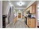 A kitchen with wood cabinets, stainless steel refrigerator, black appliances, and light wood floors at 13806 N Del Webb Blvd, Sun City, AZ 85351