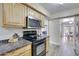 A kitchen features a black stove top, stainless steel microwave, and light wood cabinets at 13806 N Del Webb Blvd, Sun City, AZ 85351