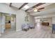 Bright, open-concept living area with wood flooring, skylights, and seamless flow to the kitchen and dining areas at 13806 N Del Webb Blvd, Sun City, AZ 85351