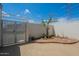 Enclosed backyard featuring white fencing, desert landscaping, and gated access for privacy at 14080 N Newcastle Dr, Sun City, AZ 85351