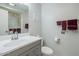 Well-lit bathroom featuring a gray vanity, toilet, and a shower with a glass door and silver fixtures at 14080 N Newcastle Dr, Sun City, AZ 85351