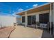 Covered patio with outdoor seating, a sliding glass door, overlooking the backyard with white fencing at 14080 N Newcastle Dr, Sun City, AZ 85351