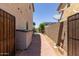 Paver walkway along the side of the house to the backyard with block wall, shed, and mature landscaping at 1446 E Douglas St, Casa Grande, AZ 85122