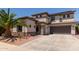 Stucco two-story home featuring a desert-landscaped yard, covered porch, and two-car garage at 1446 E Douglas St, Casa Grande, AZ 85122