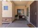 Cozy covered porch with a window, bench seating, stone accents, and a decorative welcome mat at 1446 E Douglas St, Casa Grande, AZ 85122