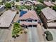 Aerial view showcasing solar panels, desert landscaping, and a three-car garage at 14878 W Windrose Dr, Surprise, AZ 85379