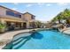 Backyard pool with a rock waterfall feature and lush landscaping, perfect for outdoor relaxation and entertainment at 14878 W Windrose Dr, Surprise, AZ 85379