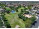 Aerial view of the community park featuring a blue basketball court, playground, ramada, and green spaces, offering recreational options at 14878 W Windrose Dr, Surprise, AZ 85379