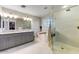 Luxurious bathroom with double vanity, soaking tub, and a glass-enclosed walk-in shower at 14878 W Windrose Dr, Surprise, AZ 85379