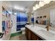 Stylish bathroom with double sinks, modern fixtures, and a shower/tub combination with a blue curtain at 14878 W Windrose Dr, Surprise, AZ 85379