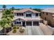 Charming two-story home with a three-car garage, well-maintained landscaping and a covered front porch at 14878 W Windrose Dr, Surprise, AZ 85379